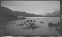 Image of 13 kayakers (seals on one), oomiak [umiak]